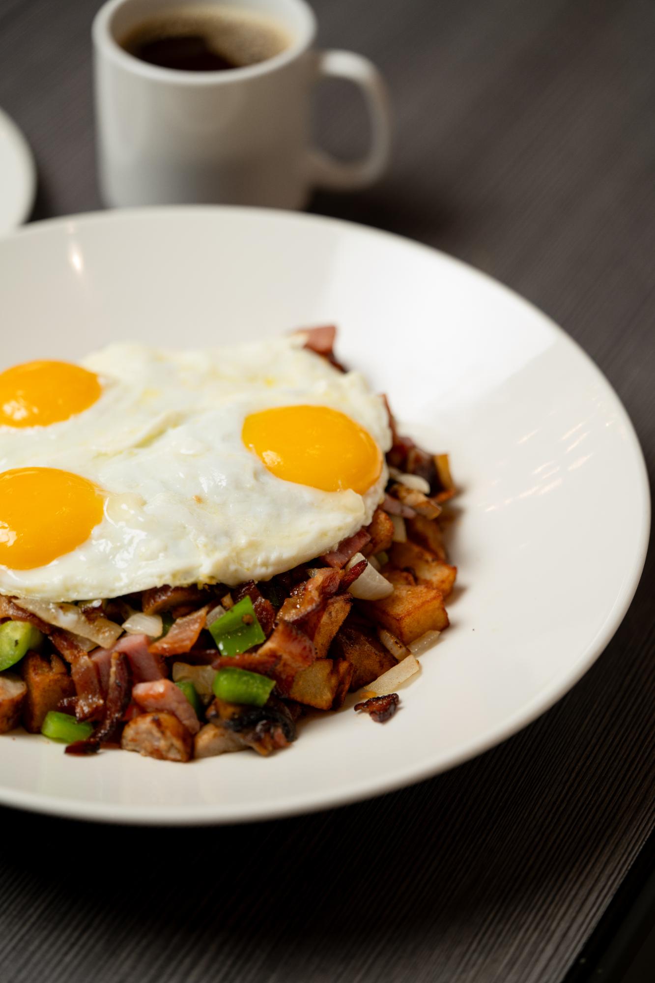 Joe's skillet with three sunny eggs, hash browns, bacon and ham